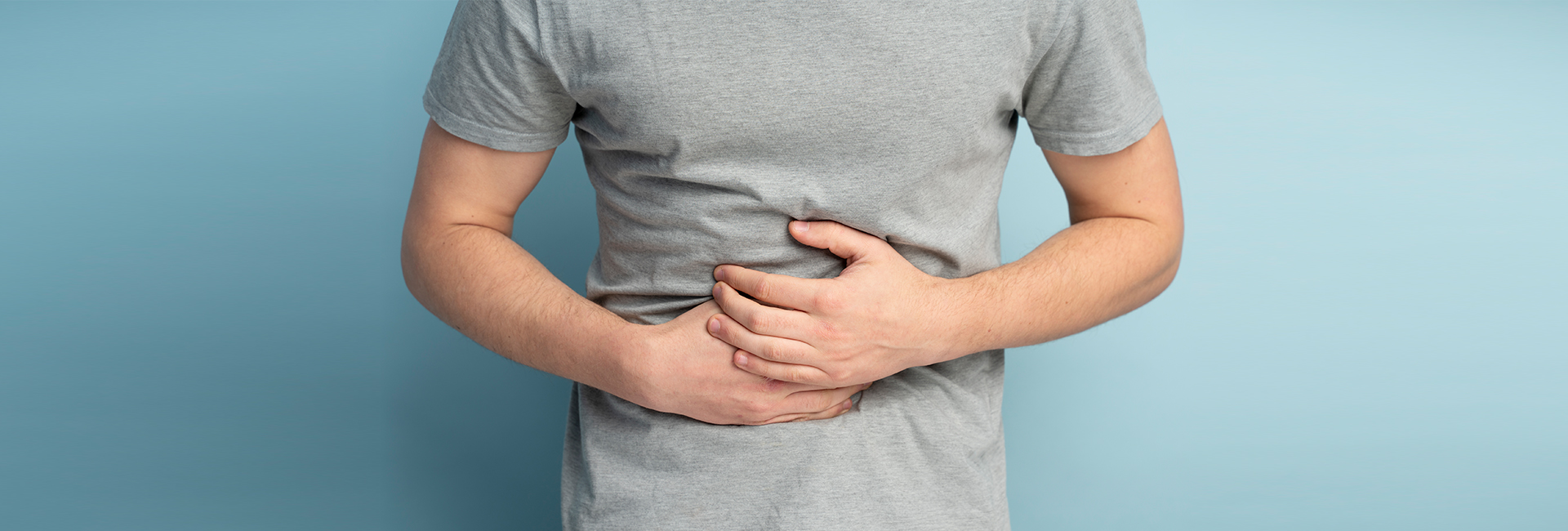 Person holding stomach, seeking functional medicine support for digestive issues in Charlotte, NC